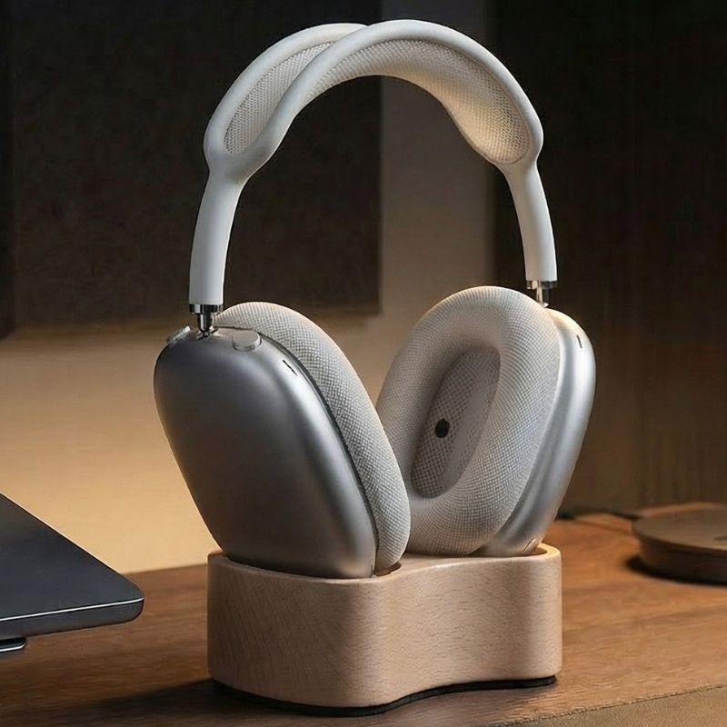 White headphones on a wooden stand with a blurred background