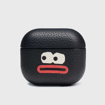 Handmade leather AirPods Pro 3 case made of lychee-grain cowhide Black leather airpod case with a cartoon face design on a light gray background