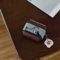 Cute Doggy AirPods Pro Case Wood Walnut Leather iwoodstore Small dog-shaped case with a tag on a wooden surface