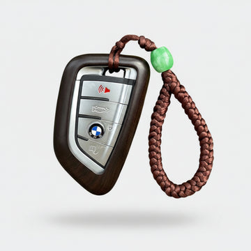 Dark ebony wood BMW key case cover with natural grain texture and polished finish