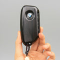 Ebony wood key case covering BMW keyless entry fob showing dark grain