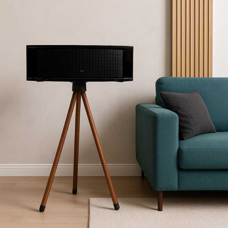 JBL L75MS Stand Holder Wood Tripod - iWoodStore Black speaker on a wooden tripod stand in a living room with a teal sofa and beige wall.