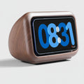 Wooden digital clock with blue LED display on a white background