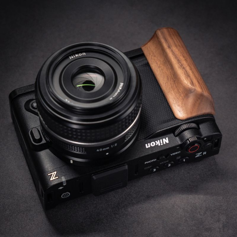 Nikon camera with wooden grip on a dark background