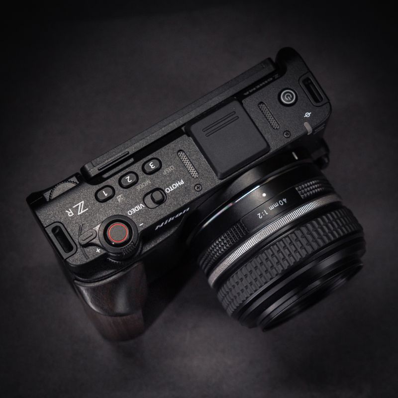 Camera body with lens on a dark background