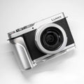A silver and black Lumix mirrorless camera with a lens attached, photographed on a clean white background.