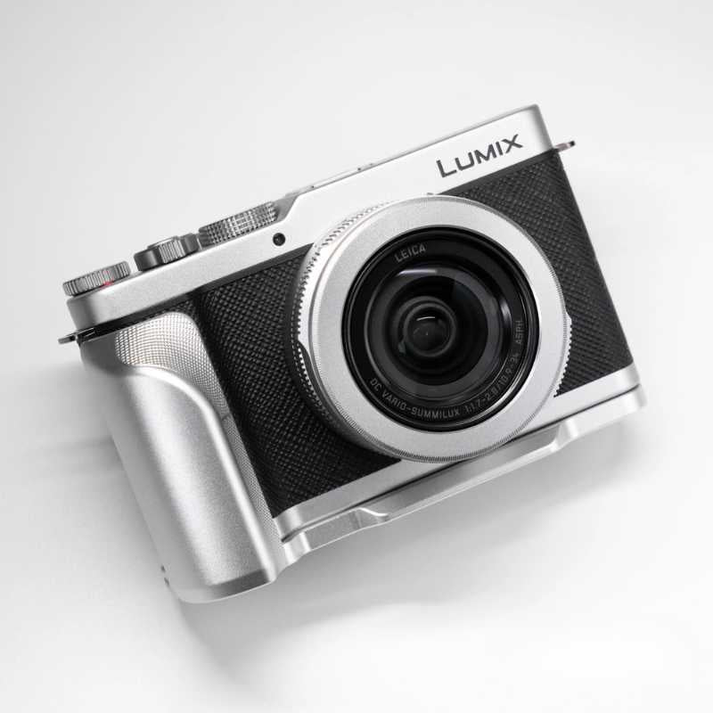 A silver and black Lumix mirrorless camera with a lens attached, photographed on a clean white background.