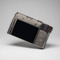 Compact camera with a flip-out screen on a dark textured surface