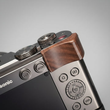 Close-up of a camera with wooden grip on a dark background