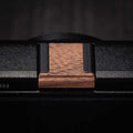 Ricoh GR4 Hotshoe Cover Wood iWoodStore Close-up of a wooden belt buckle on a black belt with a dark background