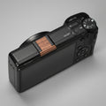 Ricoh GR4 Hotshoe Cover Wood iWoodStore Black camera with wooden grip on a dark wooden surface