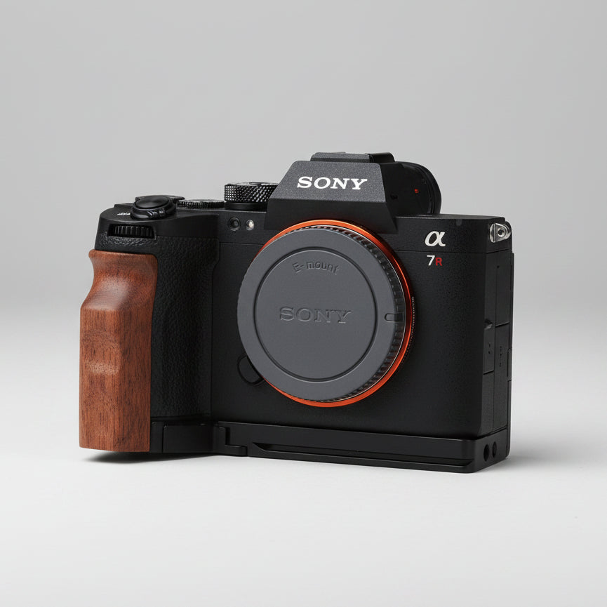 Sony Alpha mirrorless camera body with a wooden grip handle and orange accent ring, resting on dark gray textured fabric.