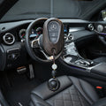 Car interior with a decorative keychain hanging from the steering wheel