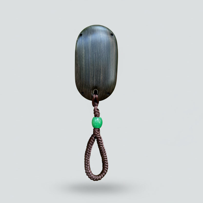 Decorative wall hook with a green bead on a gray background