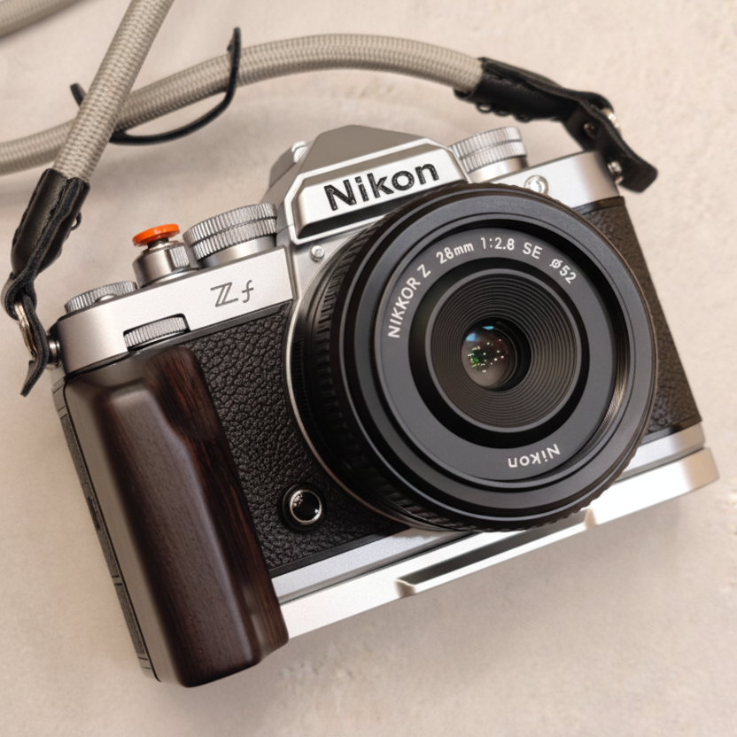 Nikon zf camera with dark ebony wooden grip silver base on a beige background